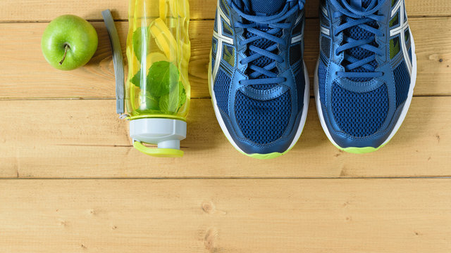 A freshly prepared drink made of lemon and mint on the background of sneakers wooden floor. The view from the top. Flat lay.