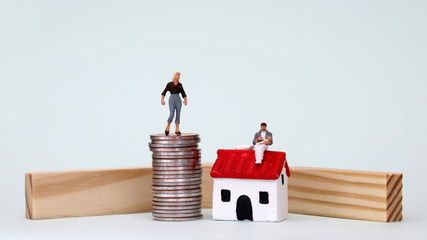 The concept of changing roles for men and women in society. A miniature woman standing on top of a...