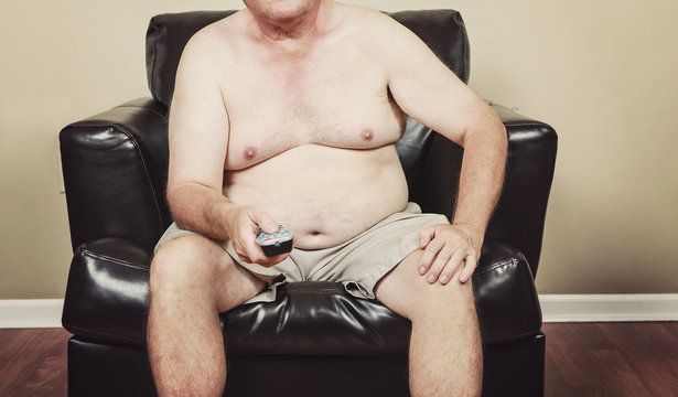 Fat man holding a remote control while watching tv