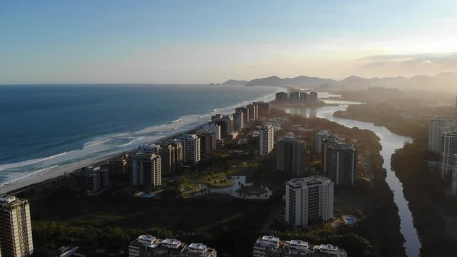 Aerial footage of Marapendi canal and Barra da Tijuca on a summer day, with the Barra and Recreio beach visible during sunset