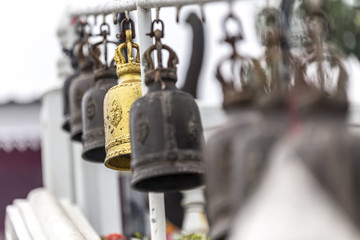 Many tranditional Wind chime on strings in a row with bokeh background