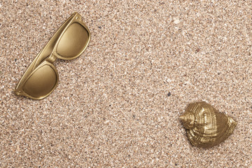 Golden sea shell and golden sunglasses on . The concept of luxury leisure. copyspace