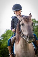 Young horse riding girl, equestrian sport . Horseback girl on field.