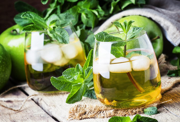 Cold apple drink, vintage wooden background, selective focus