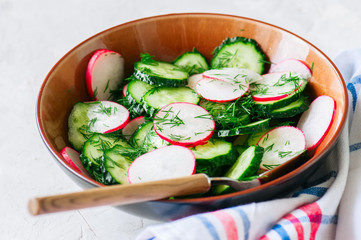 Healthy salad from fresh vegetables. Close up of cucumber and radish salad bowl. Healthy or summer food food concept.