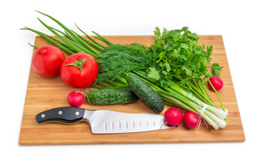 Fresh vegetables, greens and kitchen knife on bamboo cutting board