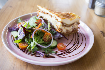 Single serving of Lasagna with some vegetables