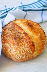 Homemade sourdough bread on a white stone background.
