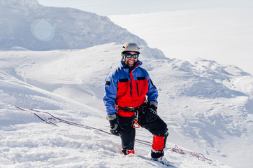 Fototapeta na wymiar Alpinist in the snowy mountains. Trekking in the mountains.