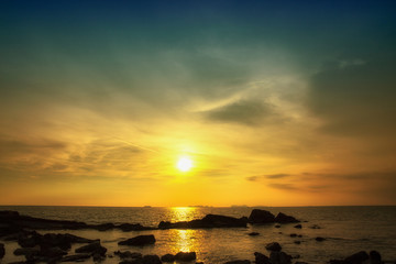 Fototapeta na wymiar Sunset seascape with rocky beach.