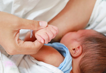 Obraz na płótnie Canvas Close up mother breast feeding her newborn child. 