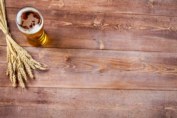 Rollo glass of beer with wheat on a wooden table background with copy space for text. flat lay, top view © 123object_stock