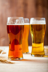 glasses of assorted beer with wheat on a wooden table background for tasting
