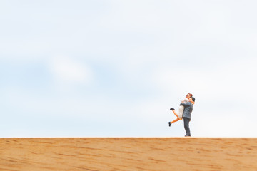 Couple hugging on wooden floor with blue sky background