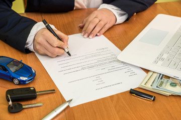 woman buys a car signing a contract