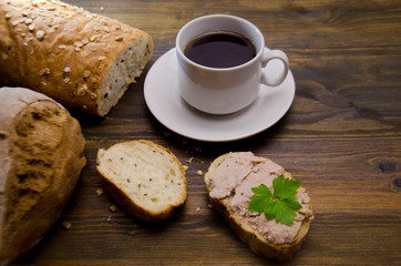 bread and sandwiches with pate and a Cup of tea on a wooden background