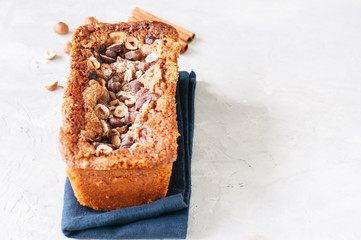 Pumpkin espresso bread with hazelnuts on a blue napkin on a white stone background. Top view and copy space.