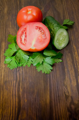 parsley and tomatoes and cucumber on wooden