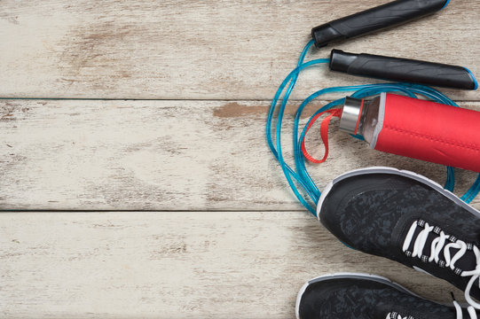 Skipping rope,Running shoes and drink bottle on wood background,top view