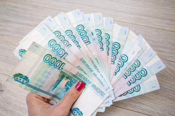 business, finance, saving, banking concept - close up bundle of money Russian Banknotes thousand rubles on wooden table