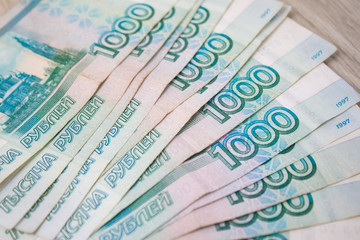 business, finance, saving, banking concept - close up bundle of money Russian Banknotes thousand rubles on wooden table