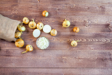 Fototapeta na wymiar fresh onions on a wooden table background. wallpaper for grocery shopping and cooking food concept. top view, flat lay