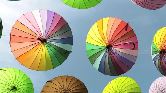 Street of colored umbrellas. Many bright umbrellas against the sky.