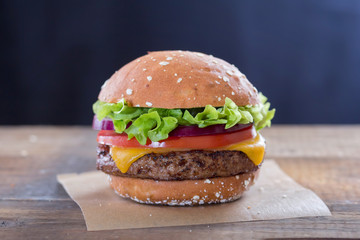 Burger with cheese, lettuce red onion and tomato 