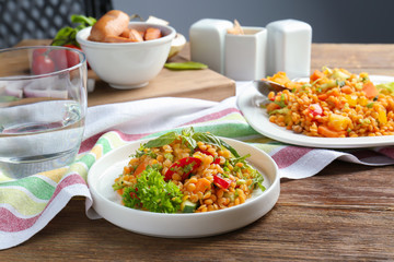 Plate with delicious lentils salad on wooden table