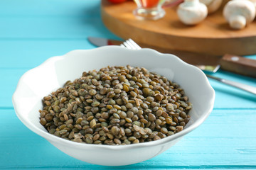 Dish with tasty lentil porridge on table