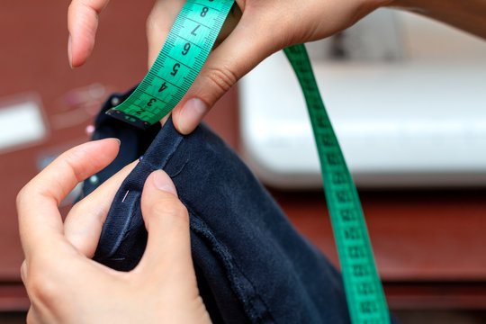 Girl tailor measures a centimeter seam leg