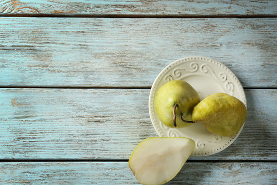 Plate with delicious pears on table