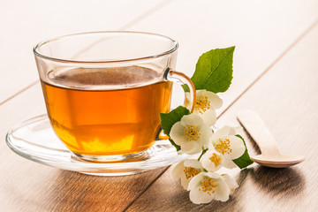 Glass cup of green tea with white jasmine flowers