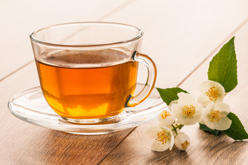 Glass cup of green tea with white jasmine flowers