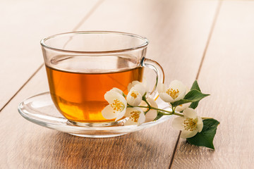 Glass cup of green tea with white jasmine flowers
