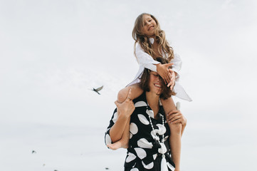 Mother and daughter holding hands and walking on beach. Mom and dauther happy family lifestyle concept
