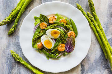 Salad with shrimps and green asparagus with peas. 
