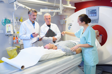 Medical staff stood around patient having scan