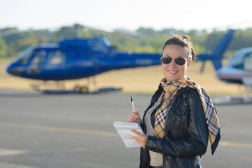 woman with notes in front of a helicopter