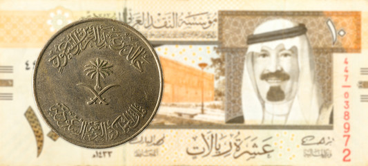 100 saudi riyal coin against 10 saudi riyal bank note