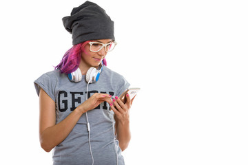 Studio shot of geek girl using mobile phone while wearing headph