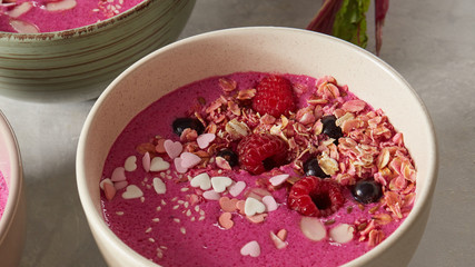 Bowl with breakfast pink smoothie from granola and almond.