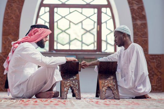 Two muslim men reading Koran in the mosque
