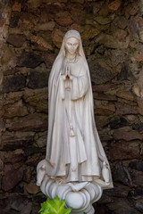 Naklejka premium White figure of Mary standing in a stone environment