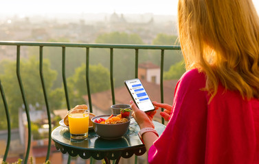 Woman chatting on phone at breakfast on terrace - obrazy, fototapety, plakaty