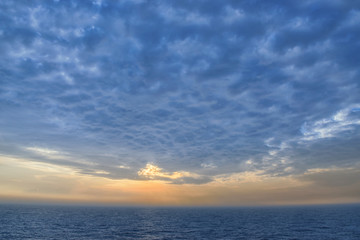 Fototapeta na wymiar dichte Wolken über dem Meer bei Sonnenuntergang