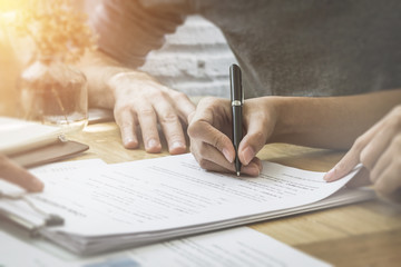 Contract signature for business and financial contract.  Sign on the dotted line.  Male caucasian pen signs a paper.