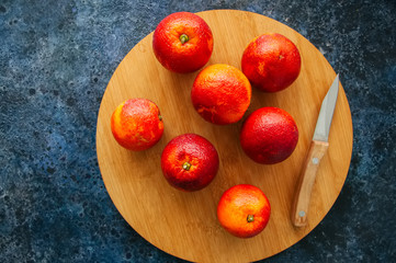 Fresh ripe blood oranges on a wooden board. Top view and copy space.