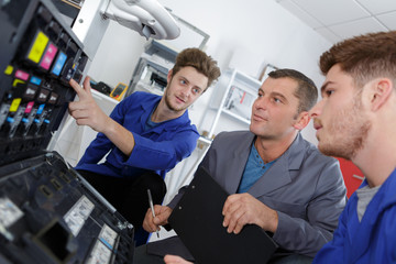 programmer apprentices fixing continuous ink supply system