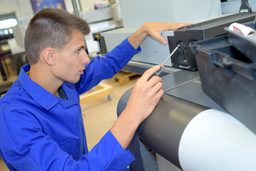 Man adjusting machine with screwdriver